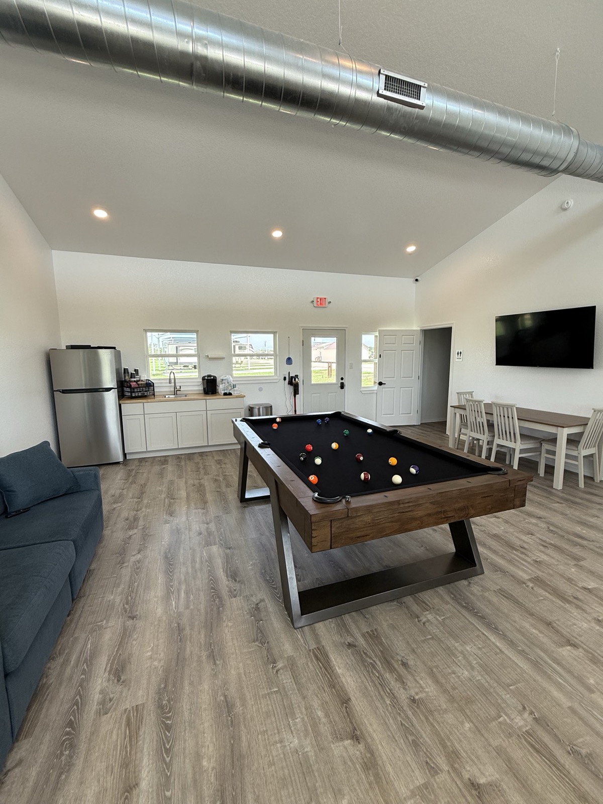 Clubhouse with pool table, lounge seating, and TV at Shade Stop RV of Floresville