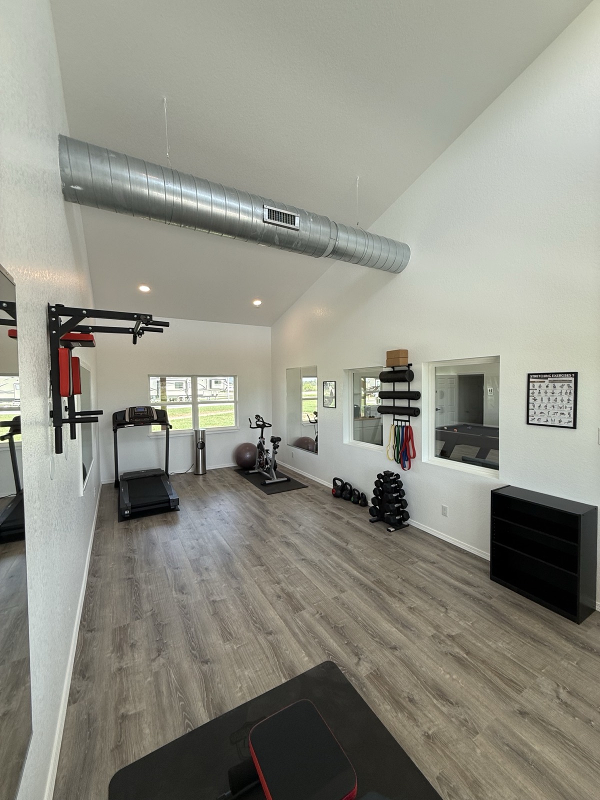 Fitness room with treadmill, exercise bike, and free weights at Shade Stop RV of Floresville