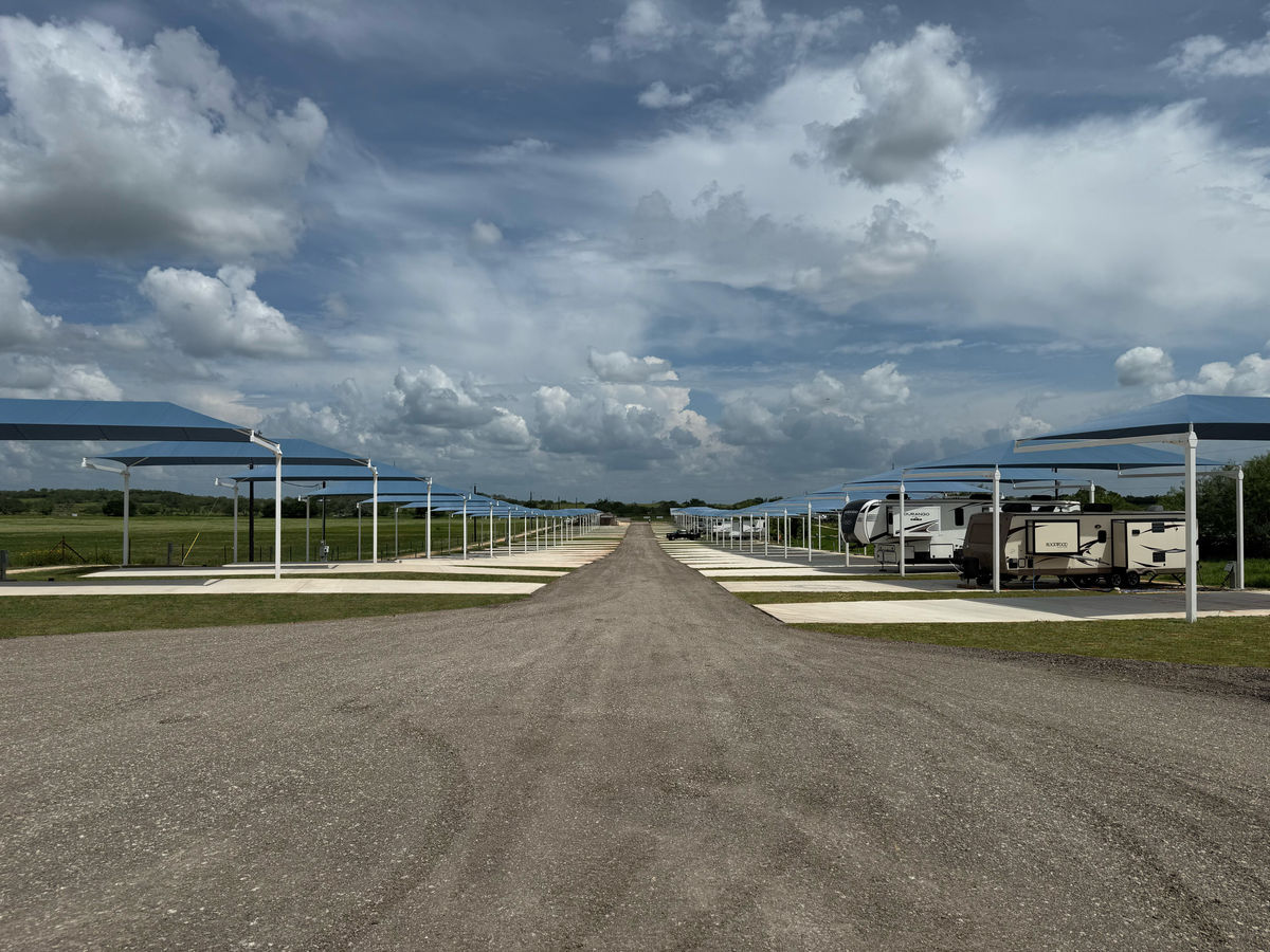 Covered RV sites with shade canopies over oversized concrete pads